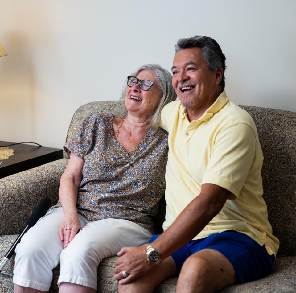 couple watching tv and laughing at home