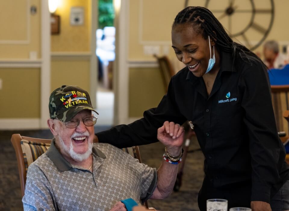 staff member laughing with a Millcroft resident
